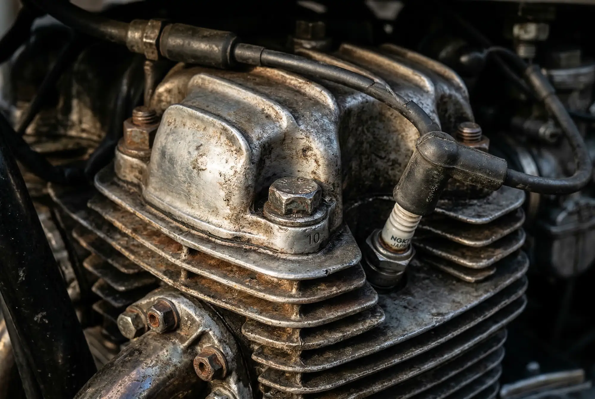 Close-up of a well-maintained high-mileage motorcycle engine showing natural wear and patina on aluminum fins