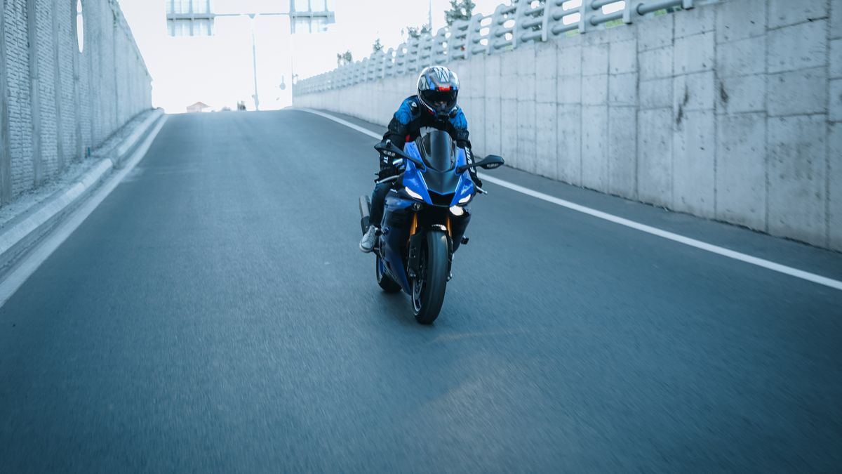 Sport motorcycle riding on a road, illustrating motorcycle purchase costs