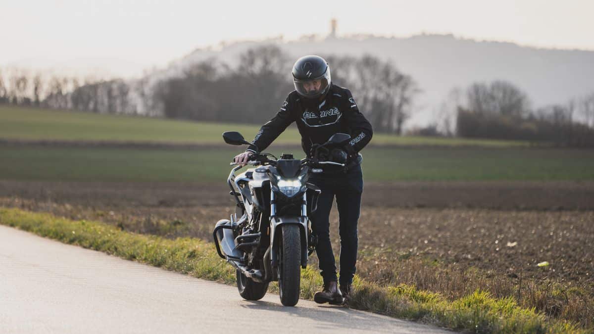 Rider next to a motorcycle, illustrating motorcycle loan payment planning
