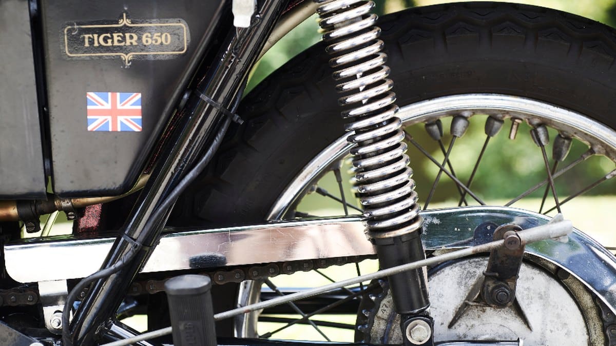Motorcycle drive chain close-up showing the pitch between pins